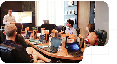 Directivo explicando a sus compañeros los nuevos programa que se lanzará para cumplir con la sexta directiva AML